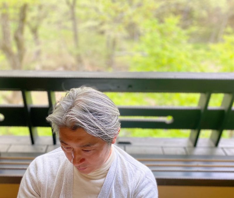 緑に囲まれたバルコニーで過ごす西田理一郎