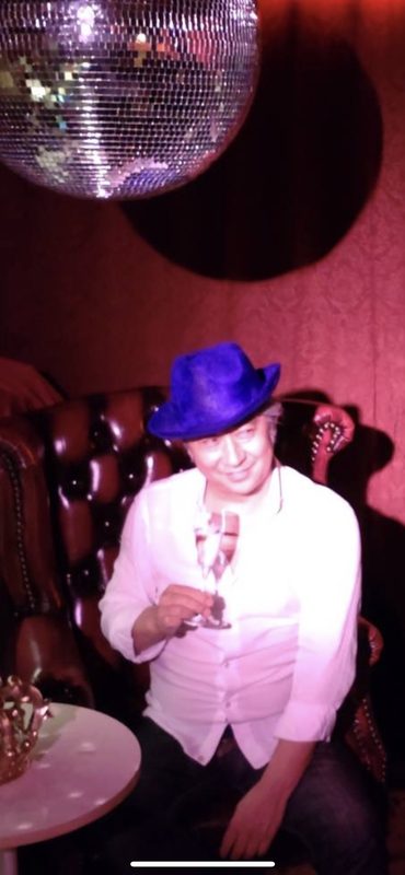 青い帽子でパーティーを楽しむ西田理一郎